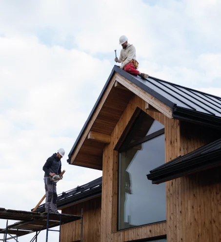 Artisan couvreur BL Habitat travaillant sur une charpente en bois lors d'une rénovation